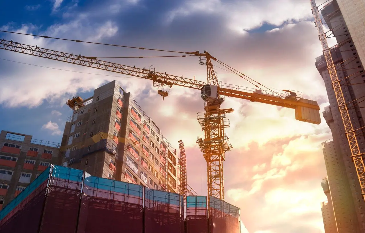 A crane is in the sky next to some buildings.